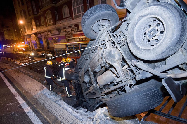 vehículo a punto de desprenderse a la calle inferior, después de romper la varandilla