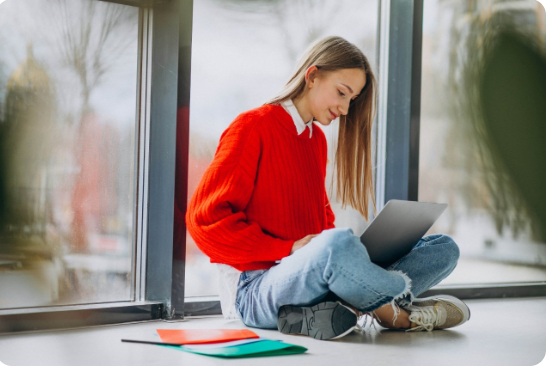 Fotografía dunha moza estudando sentada no chan.