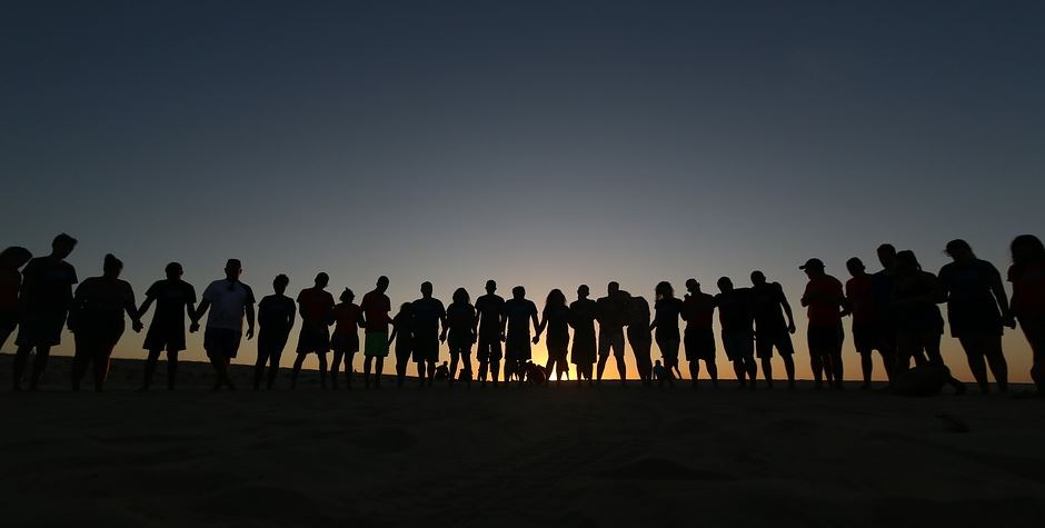 Grupo de persoas collidas polas mans.