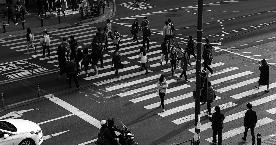 Persoas cruzando unha rúa.