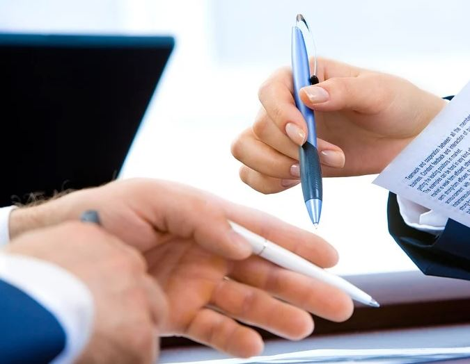 Mans con bolígrafos e documentos.