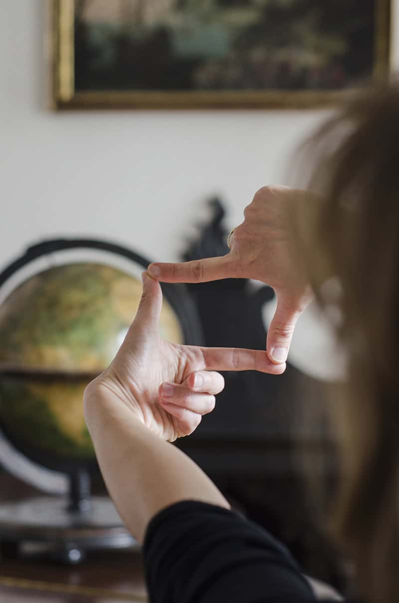globo terráqueo enmarcado por dedos humanos