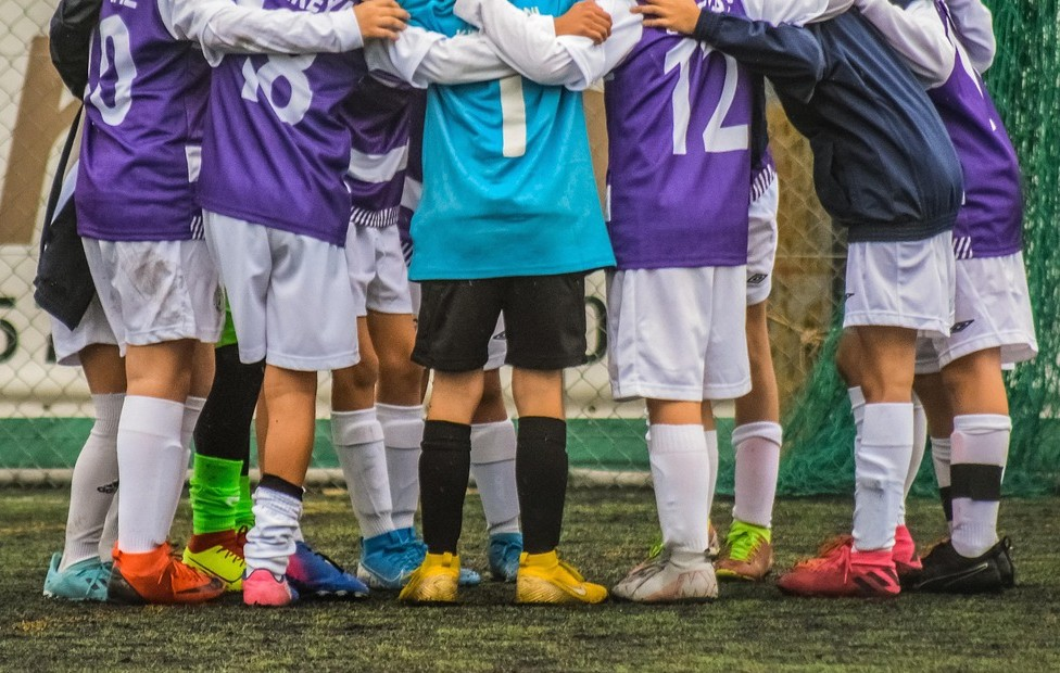 equipo de futbol infantil abrazado