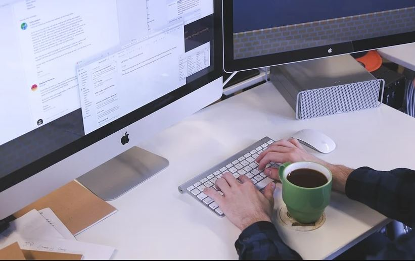 Persoa traballando nunha oficina cun ordenador.