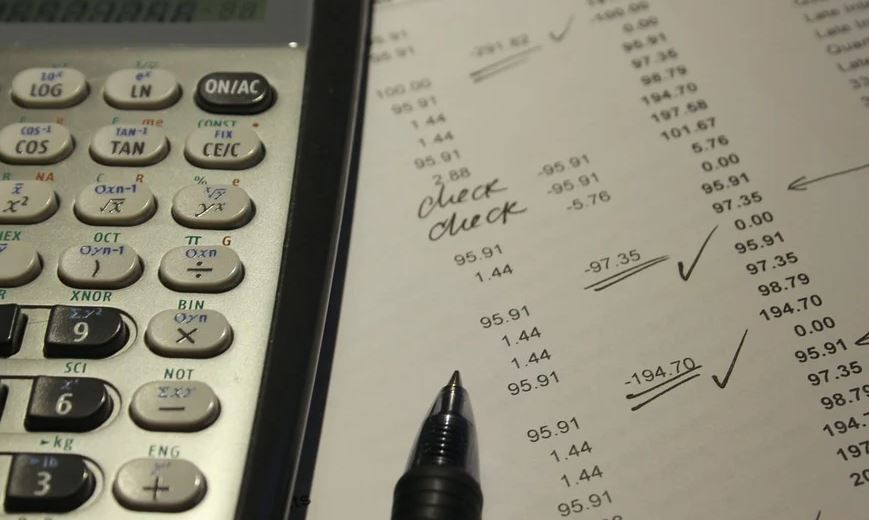 Calculadora e cifras nun papel.