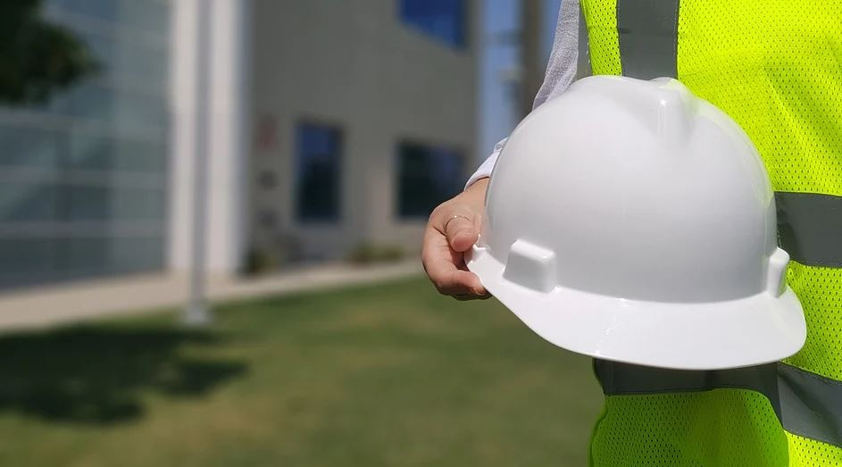 Persoa cun casco na mán.