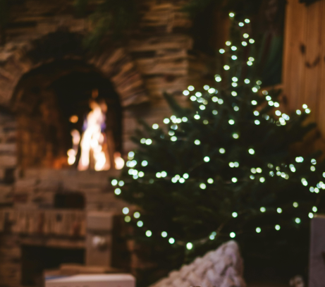cheminea de leña acesa detrás de arbol de nadal