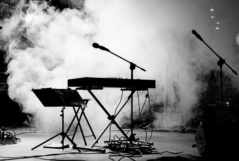Teclado e micrófonos nun escenario.