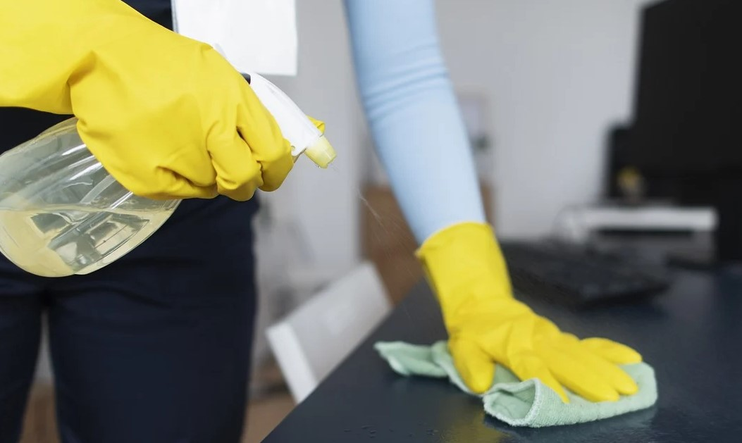 Persoa limpando unha mesa.