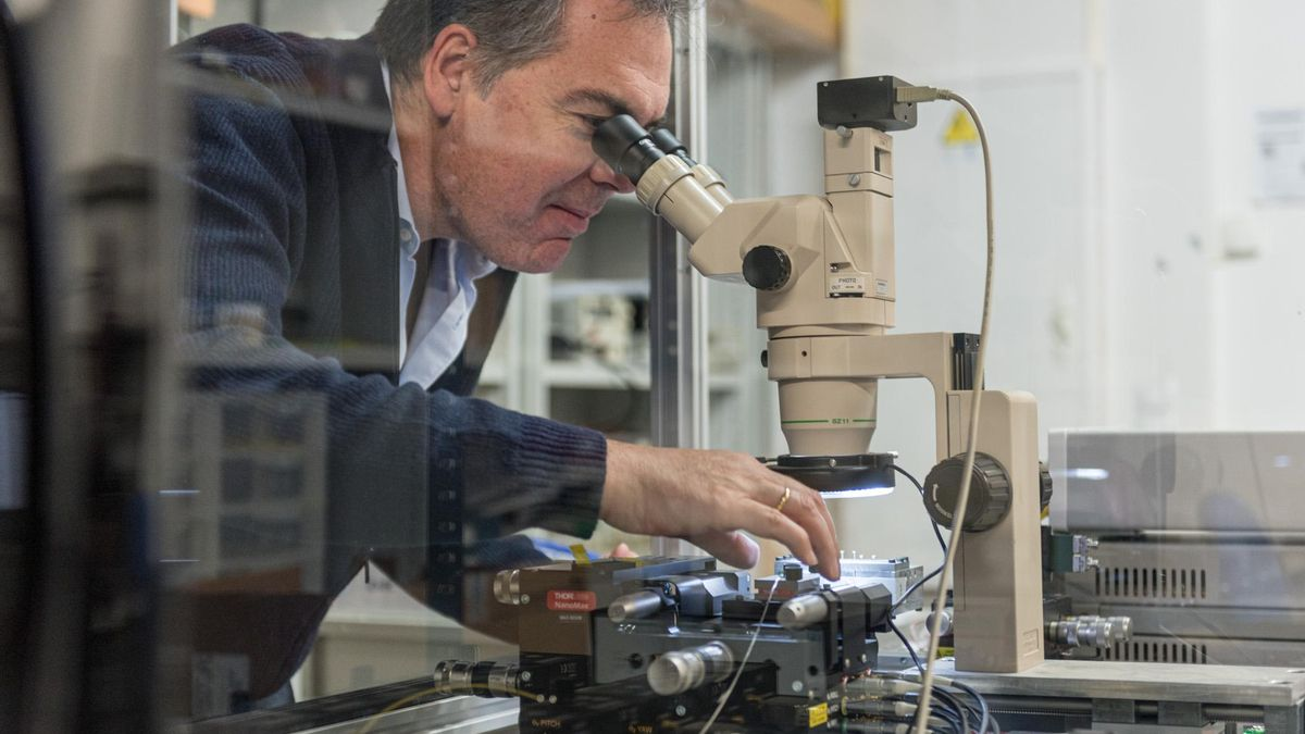 Profesor en un laboratorio mirando por un microscopio