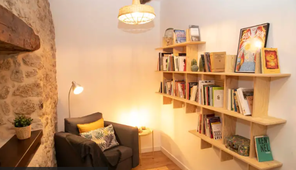 Fotografía dunha estancia cunha butaca e uns andeis.