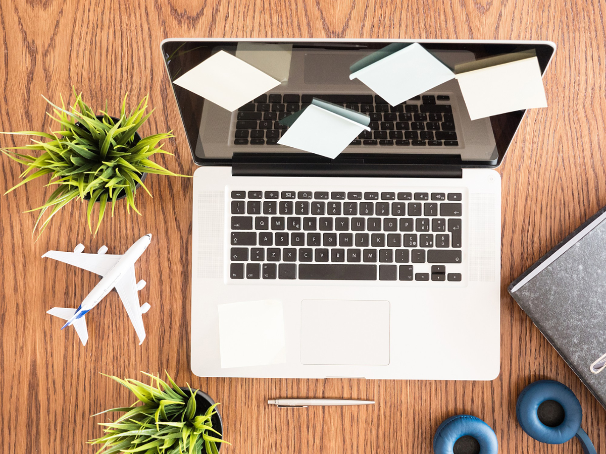 portátil sobre mesa con avión de juguete al lado