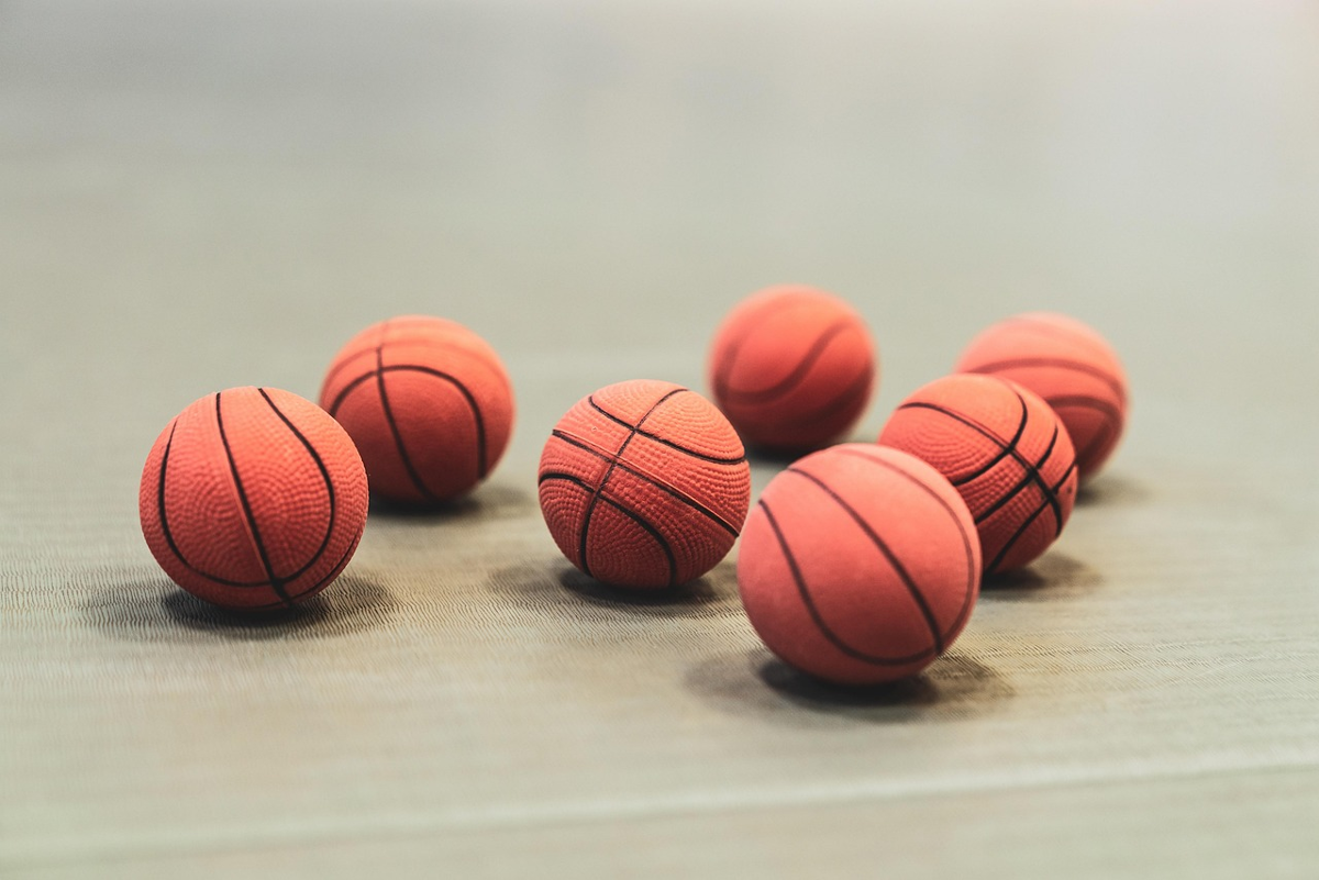 7 pelotas de baloncesto sobre o chan
