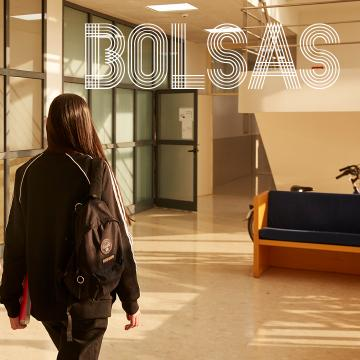 rapaza, de costas, andando pur unha das facultades da UVigo