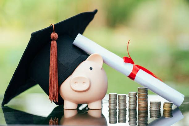 Porco de hucha cun pergamiño de graduado e un chapeu á beira dunhas moedas