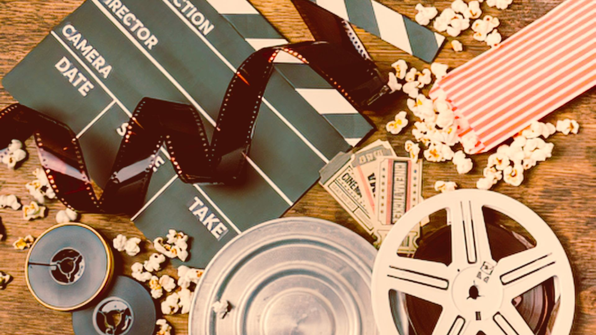 Claqueta, rollo de película e palomitas nunha mesa