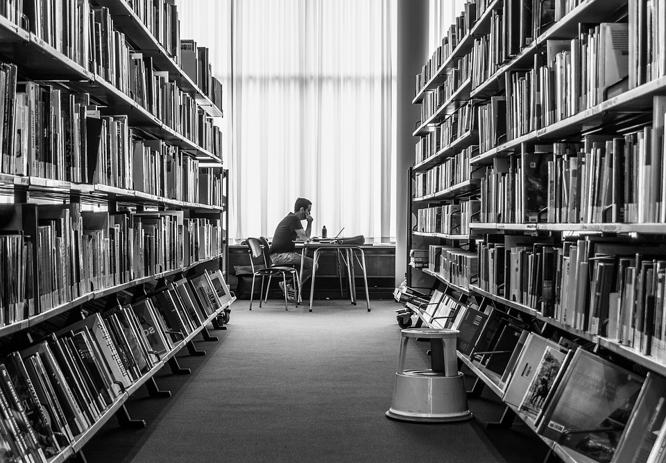 Persoa estudando nunha biblioteca.